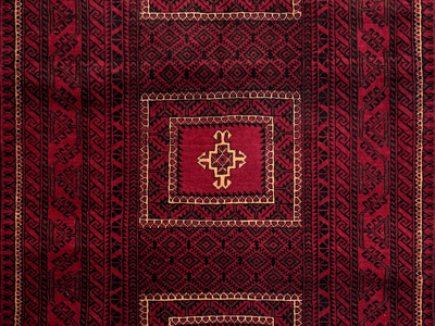 detail of a dark red and black vintage baluch rug